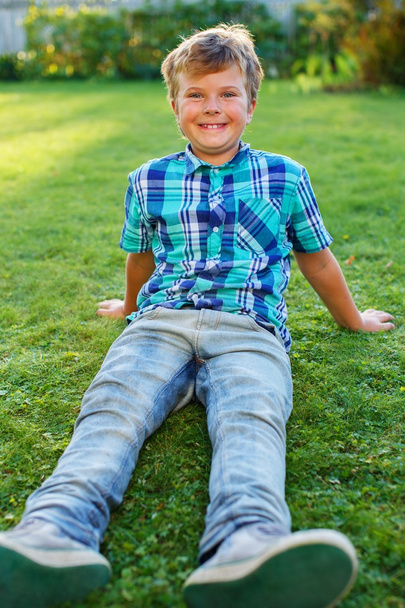 Niño sentado en un prado
 - Foto, Imagen
