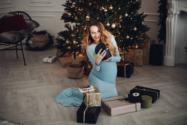Happy beautiful pregnant woman holding box with a gift - Photo, Image