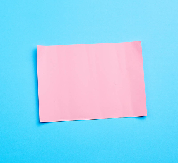 niebieski baner z różowym arkuszem papieru kręcone na wzór papieru - Zdjęcie, obraz