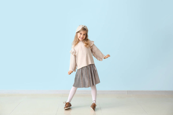 Cute little girl in autumn clothes near color wall - Foto, imagen