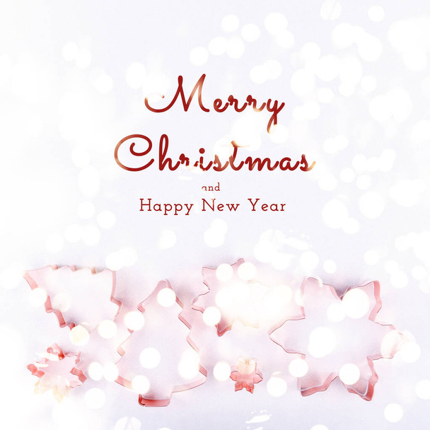 Flatlay με δέντρο διακοπών και snowflake κόπτες cookie χαλκού σε λευκό αφρώδη φόντο. Χριστούγεννα διακοπών και την έννοια της Πρωτοχρονιάς. Cozy homey λεπτομέρειες με εποχιακούς χαιρετισμούς και εορταστική bokeh φώτα - Φωτογραφία, εικόνα