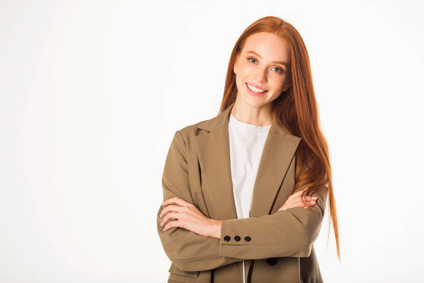 beautiful young woman with red hair in a jacket on a white background - Foto, afbeelding