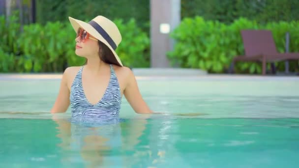 beautiful young asian woman relaxing in swimming pool  - Materiał filmowy, wideo