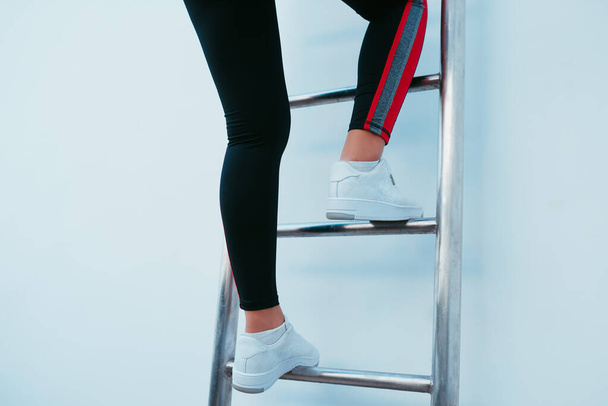 Sportieve vrouw die de ladder beklimt.  - Foto, afbeelding