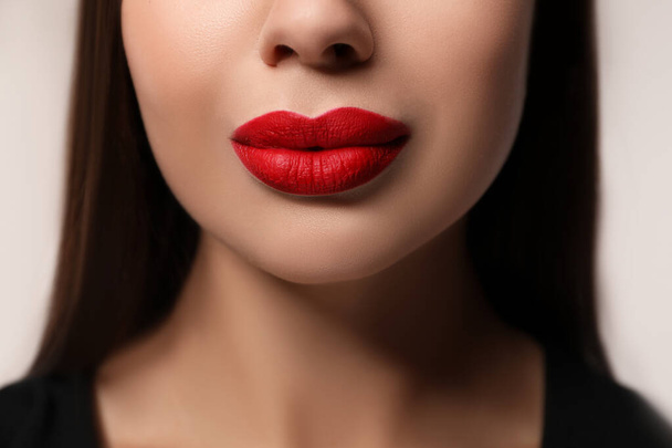 Beautiful woman with red lipstick on light background, closeup - Φωτογραφία, εικόνα