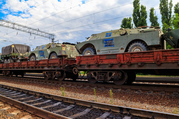 Tren de carga que transporta vehículos militares en vagones planos de ferrocarril - Foto, Imagen