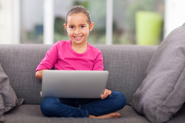little girl using laptop on sofa - Φωτογραφία, εικόνα