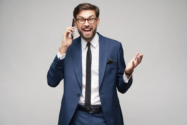 businessman talking on the phone isolated over grey background - Zdjęcie, obraz