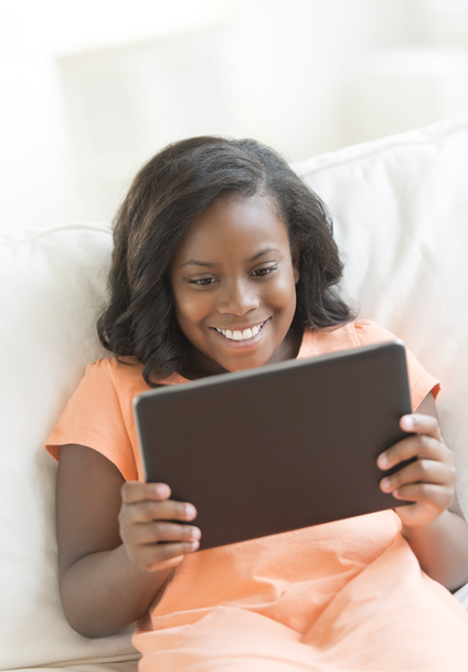 Happy Girl Using Digital Tablet On Sofa - Foto, imagen