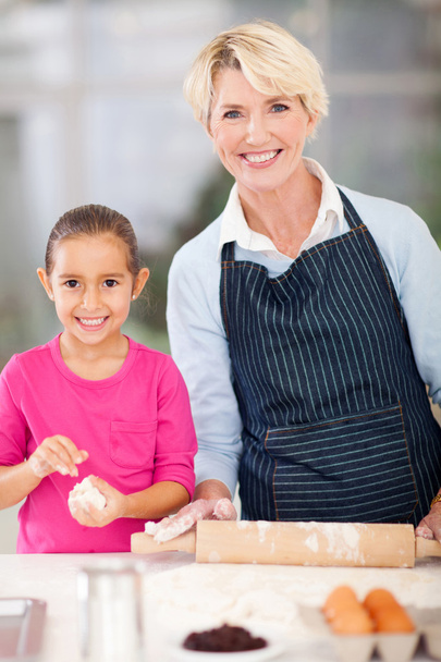 little girl and granny baking at home - 写真・画像
