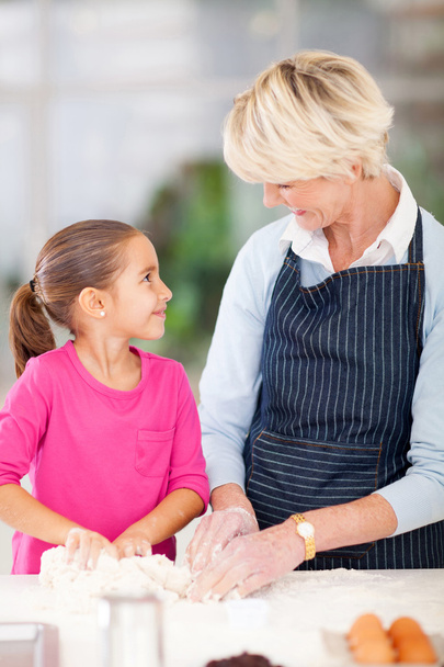 little girl helping her grandmother baking - Foto, Imagen