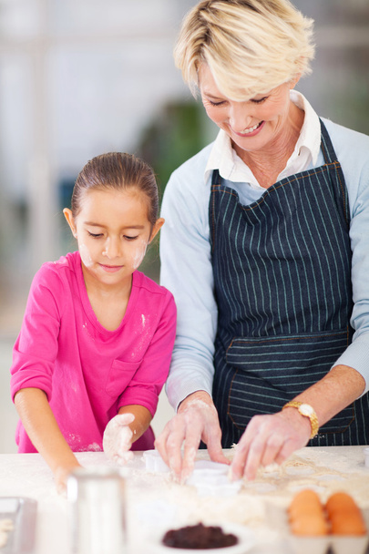 little girl with grandmother baking in kitchen - Foto, Imagen