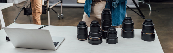 lentes de foto de tiro panorâmico perto de laptop na mesa
  - Foto, Imagem