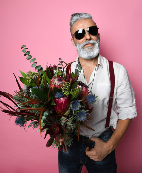 bearded middle-aged man with flowers. - Zdjęcie, obraz