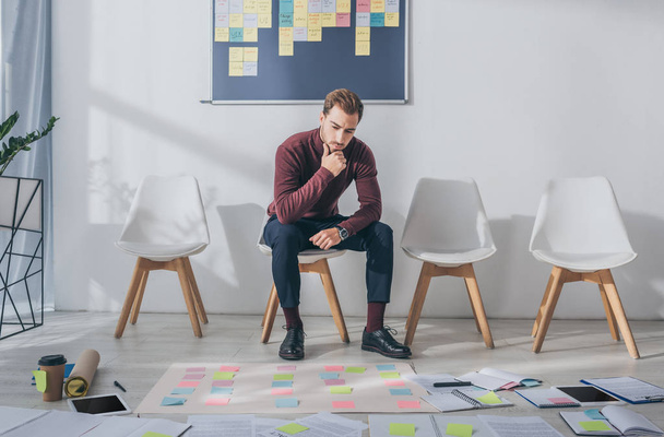 pensive businessman sitting on chair near sticky notes  - Photo, Image