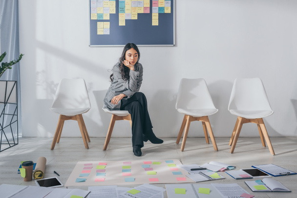 beautiful asian scrum master sitting on chair near gadgets and sticky notes  - 写真・画像