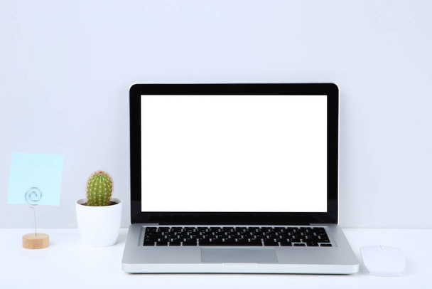 Laptop számítógép üres papírlap és zöld kaktusz gr - Fotó, kép