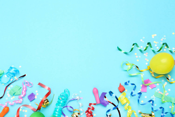 Colorful ribbons with yellow balloon and confetti on blue backgr - Foto, imagen
