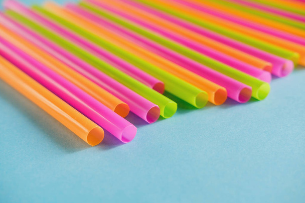 Colorful plastic Drink straws on blue background.  Equipment for single use. Plastic pollution, waste, eco, ecology, recycle. Plastic processing problem. Close up. Copy space - Photo, Image