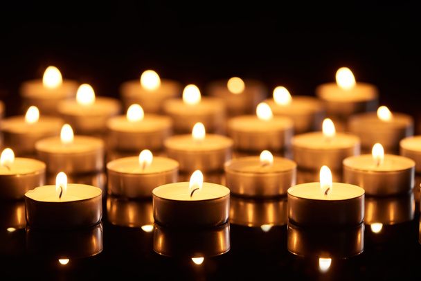 selektiver Fokus brennender Kerzen, die in der Dunkelheit leuchten - Foto, Bild