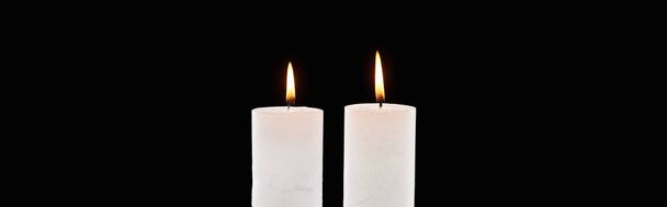 two burning white candles glowing isolated on black, panoramic shot - Photo, Image
