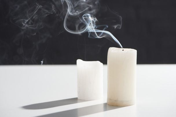 erloschene weiße Kerzen mit Rauch auf schwarzem Hintergrund - Foto, Bild
