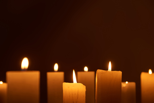 selektiver Fokus brennender Kerzen, die im Dunkeln leuchten - Foto, Bild