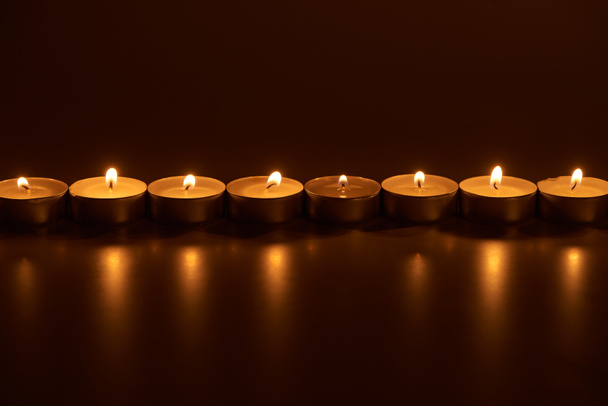 burning white candles glowing in dark - Foto, imagen