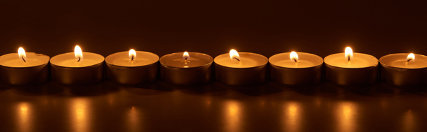 burning white candles glowing in dark, panoramic shot - Photo, Image