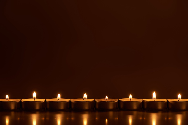 burning white candles glowing in dark - Foto, imagen