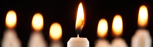 selective focus of burning white candle glowing isolated on black, panoramic shot - Photo, Image