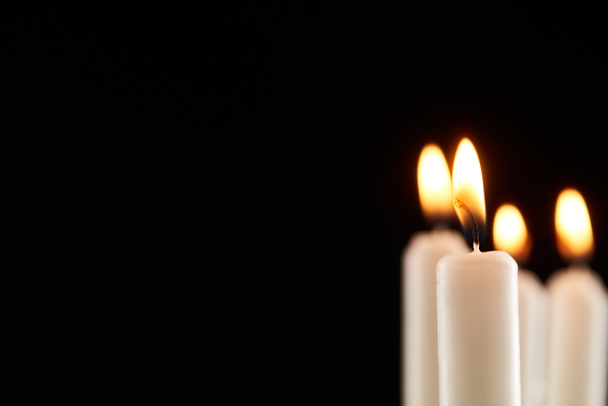 selective focus of burning white candle glowing isolated on black - Photo, Image