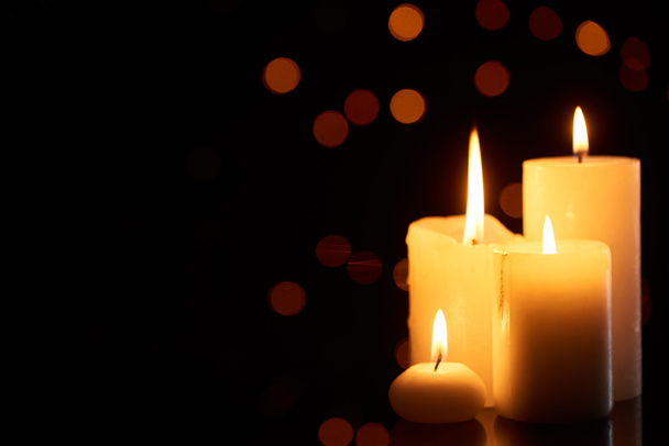 burning candles glowing in dark with bokeh lights on background - Фото, зображення