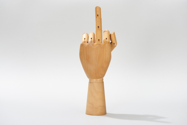 Holzhand mit Mittelfinger-Geste auf grauem Hintergrund - Foto, Bild