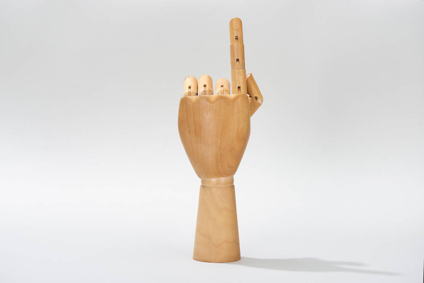 Ξύλινο χέρι μαριονέτα δείχνει με το δάχτυλο σε γκρι φόντο  - Φωτογραφία, εικόνα