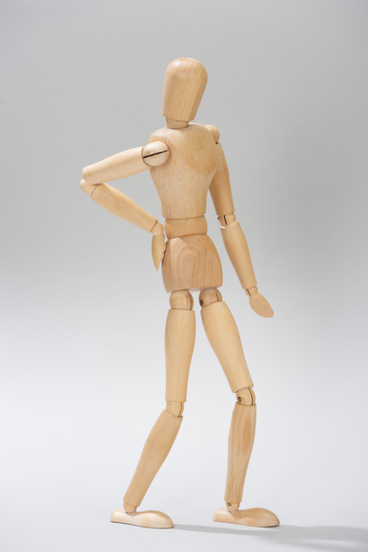 Wooden doll with hand on hip on grey background - Foto, Imagem