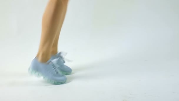 Закрыть вид на современную синюю женскую спортивную обувь на сером фоне, спортивная обувь, концепция здравоохранения
 - Кадры, видео