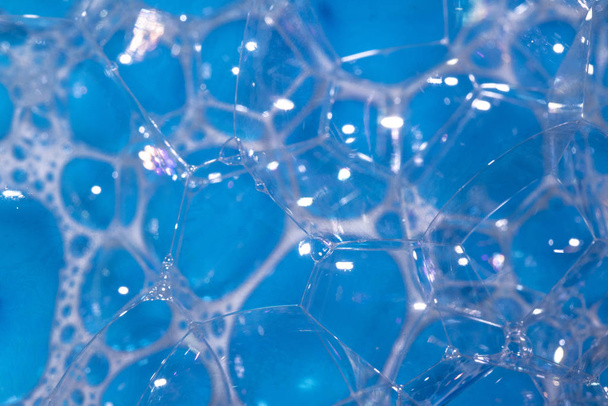 Κοντινό πλάνο του αφρού φυσαλίδων νερού μπάνιου για το υπόβαθρο στο μπλε πορφυρό ουράνιο τόξο - Φωτογραφία, εικόνα