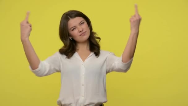 Fuck off everyone! Rebellious bully young woman with brunette hair in blouse showing middle finger gesture on all sides, expressing protest, hatred. indoor studio shot isolated on yellow background - Imágenes, Vídeo