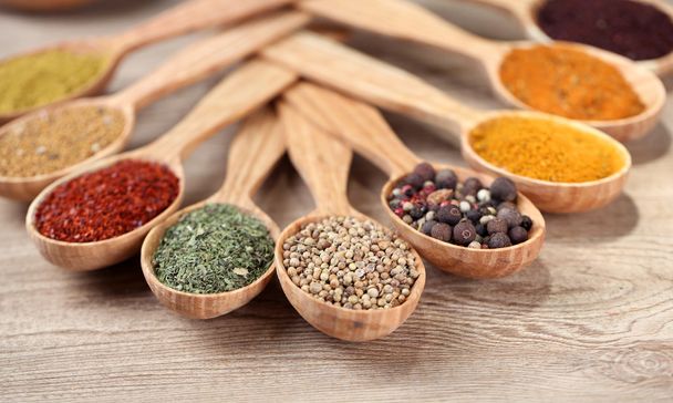 Assortment of spices in wooden spoons on wooden background - Valokuva, kuva