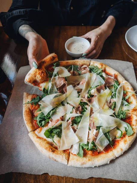 Pizza with parma ham, cheese, arugula, sauce in rustic cafe table - Fotoğraf, Görsel