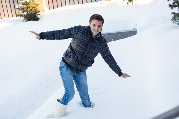 jonge man in winter laarzen viel in een diep witte sneeuw - Foto, afbeelding