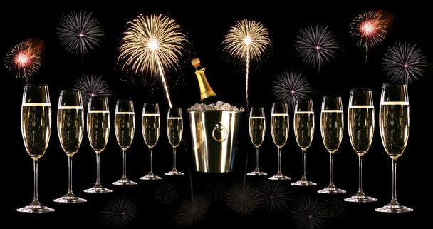 Glasses of champagne with silver ice bucket and fireworks - Photo, Image