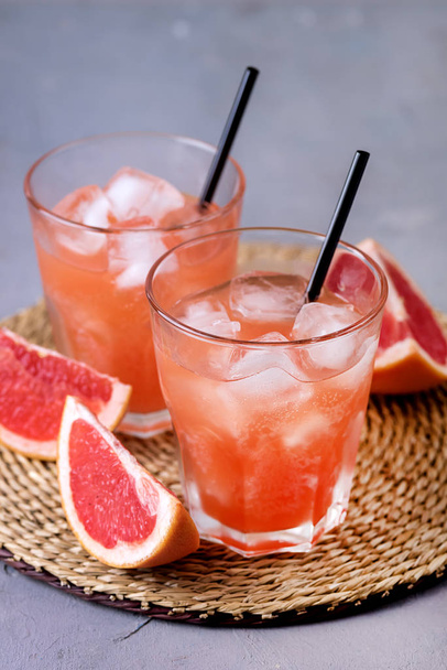 Two Glasses of Tasty Grapefruit Cold Drink or Cocktail Refreshment Beverage Gray Background Cold Grapefruit Juice Vertical - Foto, afbeelding