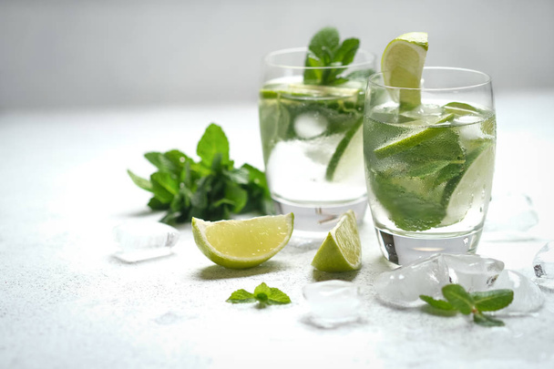 Refreshing mojito cocktail  with mint, rum and lime, cold drink or beverage with ice on white background. - Foto, Bild