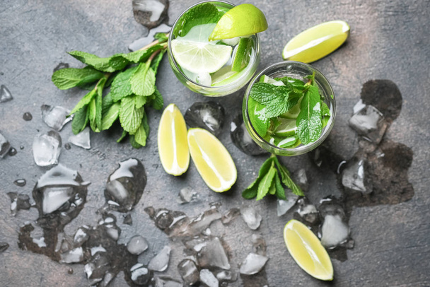 Refreshing mojito cocktail  with mint, rum and lime, cold drink or beverage with ice on dark stone table, top view - Fotoğraf, Görsel