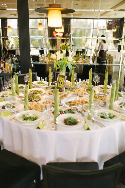 Banketový stůl na svatbě se světle zeleným přízvukem. Kulatý stůl v restauraci. - Fotografie, Obrázek