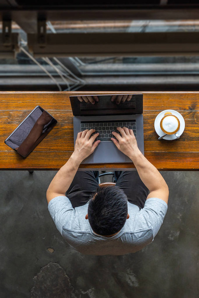 Top view photo of Asian businessman using laptop at cafeteria - Valokuva, kuva