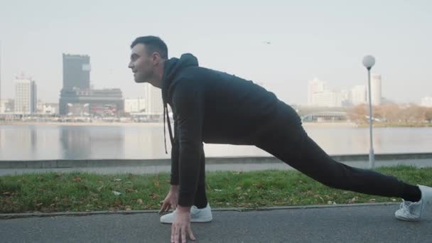 A man makes a morning stretch against the backdrop of the cityscape - Video
