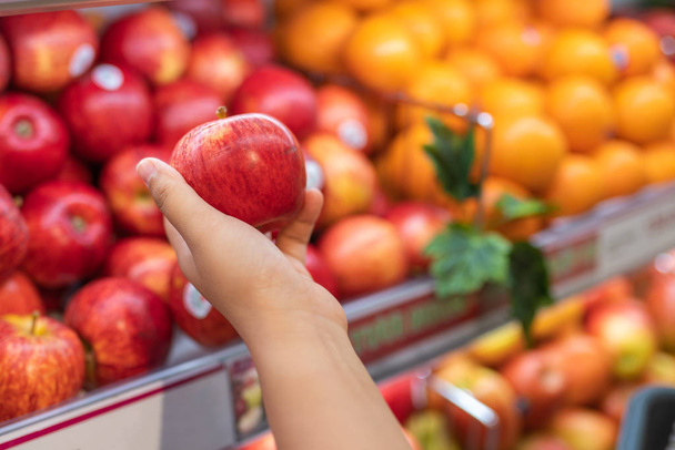 Human hand picking apple at fruit store - Φωτογραφία, εικόνα
